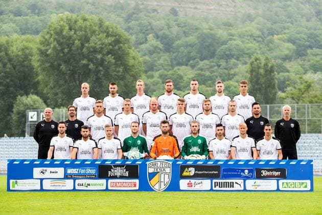 Mannschaftsfoto: Fußball, GER, 3.Liga, Porträttermin 2017 2018, Mannschaftsfoto FC Carl Zeiss Jena hi. Reihe v.li.: Rene Eckardt, Niclas Erlbeck, Sören Eismann, Jan Löhmannsröben, Maximilian Wolfram, Dominik Bock, Tom Krahnert mittlere Reihe v.li.: Torwarttrainer Bernd Lindrath, Sportpsychologe Peter Schneider, Dennis Slamar, Marius Grösch, Justin Gerlach, Florian Dietz, Timmy Thiele, Maximilian Schlegel, Co Trainer Martin Ullmann, Trainer Mark Zimmermann vor. Reihe v.li.: Matthias Kühne, Firat Sucsuz, Guillaume Cros, Jo Coppens, Raphael Koczor, Stefan Schmidt, Davud Tuma, Maximilian Weiß, Justin Schau Ernst Abbe Sportfeld