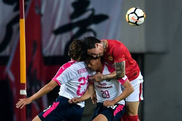 Zhang Linpeng, right, heads the ball against players of Japan s Cerezo Osaka FC in their Group G match during the 2018 AFC Champions League in Guangzhou city, south China s Guangdong province, 17 April 2018. Brazilian striker Alan Carvalho scored twice in the second half to help Guangzhou Evergrande beat the visiting side Cerezo Osaka from Japan 3-1 in a Group G game, final round of the AFC Champions League group stage on Tuesday night. After this game, Guangzhou Evergrande remained unbeaten in this group, earning 12 points and place the first to progress to the knock-out stage of the AFC Champions League, while Buriram United from Thailand managed a 1-0 win over home team Jeju United from South Korea and secured another place in the knock-out stage. Huang Bowen broke the deadlock for Guangzhou Evergrande early in the fifth minute, as the 30-year-old midfielder received the pass from Li Xuepeng, got away from defenders in the penalty area and scored the opening goal. Guangzhou Evergrande beat Cerezo Osaka 3-1 in AFC Champions League 20180417_71136