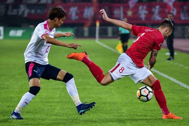 Serbian football player Nemanja Gudelj, right, of China s Guangzhou Evergrande Taobao FC, challenges Tatsuya Yamashita of Japan s Cerezo Osaka FC in their Group G match during the 2018 AFC Champions League in Guangzhou city, south China s Guangdong province, 17 April 2018. Brazilian striker Alan Carvalho scored twice in the second half to help Guangzhou Evergrande beat the visiting side Cerezo Osaka from Japan 3-1 in a Group G game, final round of the AFC Champions League group stage on Tuesday night. After this game, Guangzhou Evergrande remained unbeaten in this group, earning 12 points and place the first to progress to the knock-out stage of the AFC Champions League, while Buriram United from Thailand managed a 1-0 win over home team Jeju United from South Korea and secured another place in the knock-out stage. Huang Bowen broke the deadlock for Guangzhou Evergrande early in the fifth minute, as the 30-year-old midfielder received the pass from Li Xuepeng, got away from defenders in the penalty area and scored the opening goal. Guangzhou Evergrande beat Cerezo Osaka 3-1 in AFC Champions League 20180417_72016