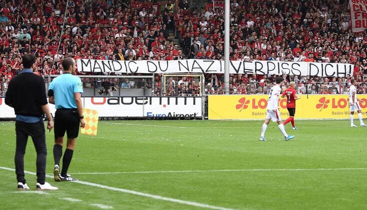 17 08 2019, xfux, football 1 Bundesliga, SC Freiburg 1 FSV Mainz 05, azspor, emspor, v l Fans SC Freiburg, fan, mood, jersey, scarf, flag, emotions with a banner against Mandic Protest ãMandic du Nazi Fuck off Ò DFL DFB REGULATIONS PROHIBIT ANY USE OF PHOTOGRAPHS as IMAGE SEQUENCES and or QUASI VIDEO Freiburg