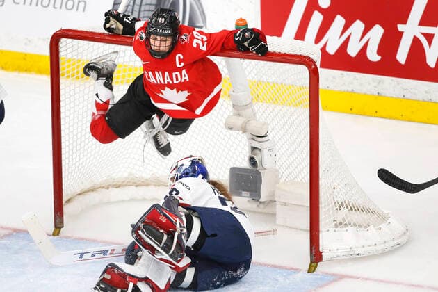 Canada player Marie-Philip Poulin, top, holds onto the crossbar to avoid contact with USA goalie Nicole Hensley, bott, during IIHF Women s World Championship, WM, Weltmeisterschaft gold medal play in Calgary, Alberta, Canada on Aug. 31, 2021. digital photo by Larry MacDougal Marie-Philip Poulin, Nicole Hensley