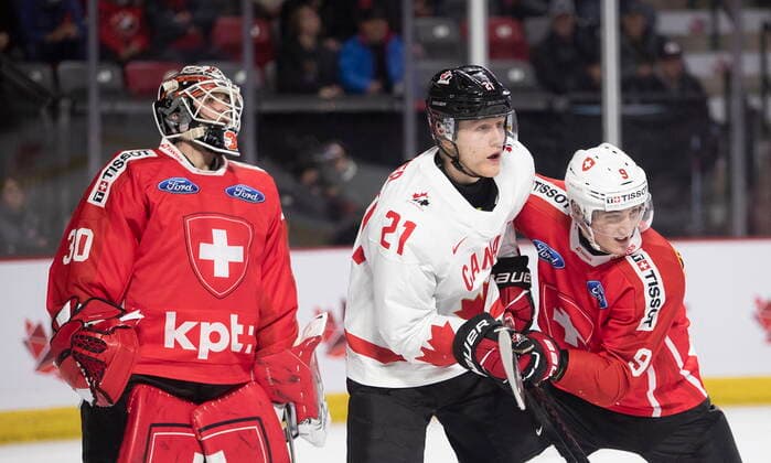 December 19, 2022, Moncton, NB, Canada: Switzerland goaltender Kevin Pasche looks for the puck as Canada™s Nathan Gaucher, centre, and Switzerland™s Brian Zanetti battle in front of him during second period IIHF World Junior Hockey Championship pre-tournament hockey action in Moncton, N.B., on Monday, Dec. 19, 2022. Canada News - December 19, 2022 - ZUMAc35_ 20221219_zaf_c35_063 Copyright: xRonxWardx