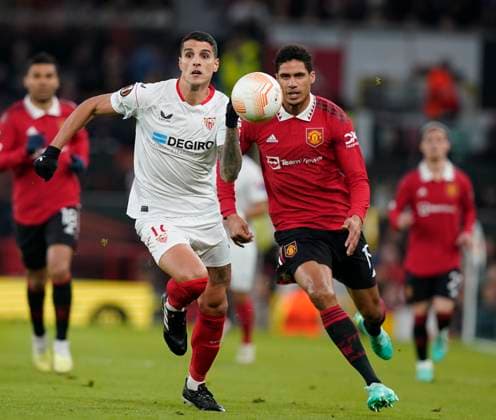 Manchester, England, 13th April 2023. Erik Lamela of Sevilla gets ahead of Raphael Varane of Manchester United, ManU during the UEFA Europa League match at Old Trafford, Manchester. Picture credit should read: Andrew Yates Sportimage EDITORIAL USE ONLY. No use with unauthorised audio, video, data, fixture lists, club league logos or live services. Online in-match use limited to 120 images, no video emulation. No use in betting, games or single club league player publications. SPI-2367-0021