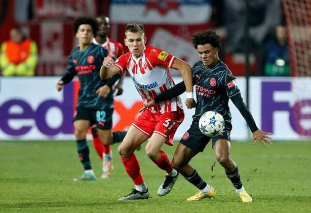 Oscar Bobb of Manchester City is challenged by Milos Degenek of Red Star Crvena zvezda v Manchester City, UEFA Champions League, Group G, Football, Rajko Mitic Stadium, Belgrade, Serbia - 13 Dec 2023 EDITORIAL USE ONLY No use with unauthorised audio, video, data, fixture lists, club league logos or live services. Online in-match use limited to 120 images, no video emulation. No use in betting, games or single club league player publications. Copyright: xNikolaxKrstic Shutterstockx 14254230di