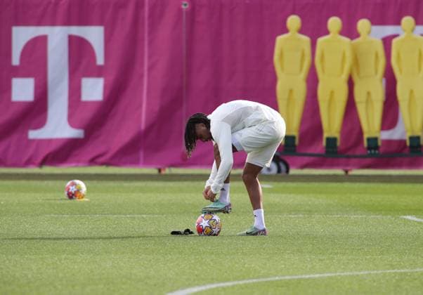 Munich, Germany February 13, 2024 Football, Men, Season 2023 2024, FC Bayern Munich, Säbener Strasse, Training ground, Final training, Champions League Sacha Boey FC Bayern Munich bent forward while tying shoes, shoelaces