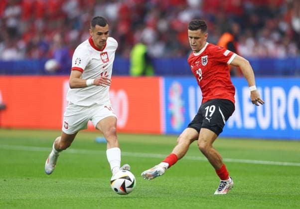 Christoph Baumgartner of Austria passes the ball whilst under pressure from Jakub Kiwior of Poland Poland v Austria, UEFA European Championship, EM, Europameisterschaft 2024, Group D, Football, Olympiastadion, Berlin, Germany, 21 Jun 2024 EDITORIAL USE ONLY No use with unauthorised audio, video, data, fixture lists, club league logos or live services. Online in-match use limited to 120 images, no video emulation. No use in betting, games or single club league player publications. Copyright: xKieranxMcManus Shutterstockx 14543876v