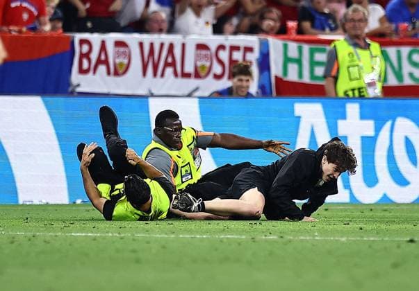 Stewards tackle a pitch invader Denmark v Serbia, UEFA European Championship, EM, Europameisterschaft 2024, Group C, Football, Munich Football Arena, Munich, Germany, 25 Jun 2024 EDITORIAL USE ONLY No use with unauthorised audio, video, data, fixture lists, club league logos or live services. Online in-match use limited to 120 images, no video emulation. No use in betting, games or single club league player publications. Copyright: xMichaelxZemanek Shutterstockx 14555536ct