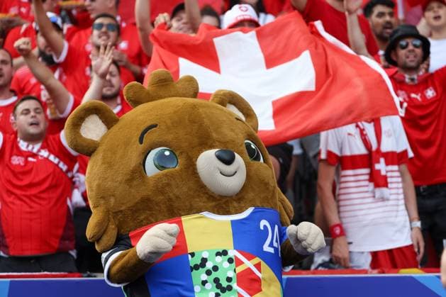 Swiss fan block, mascot Albärt, large Swiss flag, fans dressed in red, Berlin, UEFA EURO 2024, cheering crowd, enthusiastic supporters, seats filled, security service, summer, festive atmosphere, fans in red, soccer enthusiasm, grandstand, sports event, national team, stadium, passion, soccer mascot Albärt , football, UEFA , European Championship, round of 16 2024, Switzerland vs Italy, 29 06 2024, Olympiastadion Berlin, Berlin, Germany Berlin Olympiastadion Berlin Berlin Germany Copyright: xGrantxHubbsx