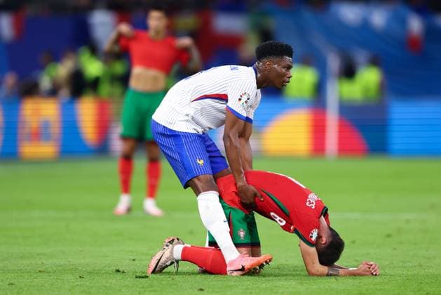 Aurà lien Tchouamà ni of France helps pick Bruno Fernandes of Portugal up Portugal v France, UEFA European Championship, EM, Europameisterschaft 2024, Quarter Final, Football, Volksparkstadion, Hamburg, Germany, 05 Jul 2024 EDITORIAL USE ONLY No use with unauthorised audio, video, data, fixture lists, club league logos or live services. Online in-match use limited to 120 images, no video emulation. No use in betting, games or single club league player publications. Copyright: xKieranxMcManus Shutterstockx 14571382aw