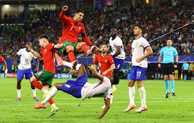 Cristiano Ronaldo of Portugal is sent flying after a challenge with Aurà lien Tchouamà ni of France Portugal v France, UEFA European Championship, EM, Europameisterschaft 2024, Quarter Final, Football, Volksparkstadion, Hamburg, Germany, 05 Jul 2024 EDITORIAL USE ONLY No use with unauthorised audio, video, data, fixture lists, club league logos or live services. Online in-match use limited to 120 images, no video emulation. No use in betting, games or single club league player publications. Copyright: xKieranxMcManus Shutterstockx 14571382gx