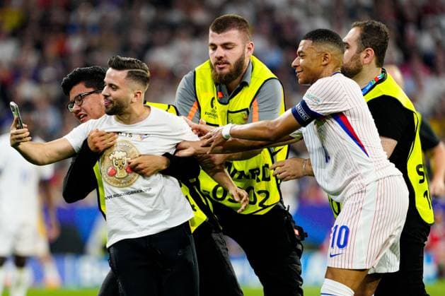 A pitch invader runs on the pitch for a selfie with Kylian Mbappà of France Spain v France, UEFA European Championship, EM, Europameisterschaft 2024, Semi Final, Football, Munich Football Arena, Munich, Germany - 09 Jul 2024 EDITORIAL USE ONLY No use with unauthorised audio, video, data, fixture lists, club league logos or live services. Online in-match use limited to 120 images, no video emulation. No use in betting, games or single club league player publications. Copyright: xDavexShopland Shutterstockx 14576888ct
