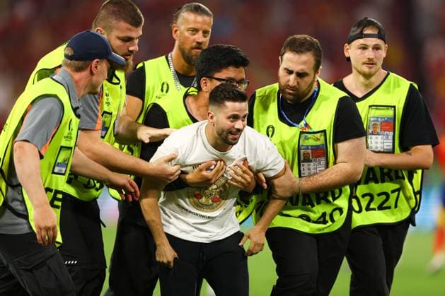A pitch invader is detained by security Spain v France, UEFA European Championship, EM, Europameisterschaft 2024, Semi Final, Football, Munich Football Arena, Munich, Germany - 09 Jul 2024 EDITORIAL USE ONLY No use with unauthorised audio, video, data, fixture lists, club league logos or live services. Online in-match use limited to 120 images, no video emulation. No use in betting, games or single club league player publications. Copyright: xKieranxMcManus Shutterstockx 14576874dc