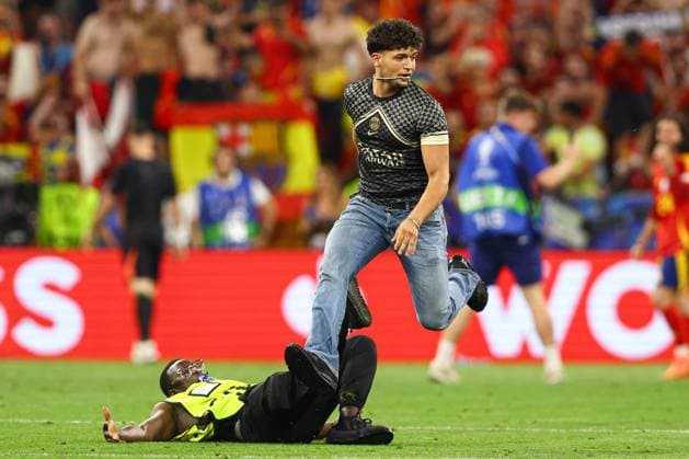A pitch invader is tackled by security at full-time Spain v France, UEFA European Championship, EM, Europameisterschaft 2024, Semi Final, Football, Munich Football Arena, Munich, Germany - 09 Jul 2024 EDITORIAL USE ONLY No use with unauthorised audio, video, data, fixture lists, club league logos or live services. Online in-match use limited to 120 images, no video emulation. No use in betting, games or single club league player publications. Copyright: xKieranxMcManus Shutterstockx 14576874dy