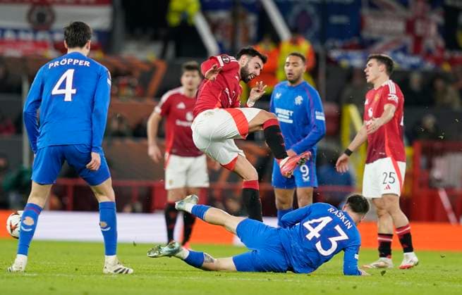 Manchester, England, 23rd January 2025. Bruno Fernandes of Manchester United, ManU (C) is challenged by Nicolas Raskin of Rangers during the UEFA Europa League match at Old Trafford, Manchester. Picture credit should read: Andrew Yates Sportimage EDITORIAL USE ONLY. No use with unauthorised audio, video, data, fixture lists, club league logos or live services. Online in-match use limited to 120 images, no video emulation. No use in betting, games or single club league player publications. SPI_050_AY_MAN_UTD_RANGERS SPI-3616-0048