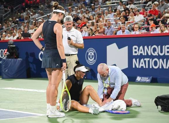 July 27, 2025, Montreal, Pq, Canada: Barbora Krejcikova, of the Czech Republic, left, looks on as Bianca Andreescu, of Canada, receives treatment on court following a slip during their first round match at the National Bank Open tennis tournament in Montreal, Sunday, July 27, 2025. Barbora Krejcikova, Bianca Andreescu, - ZUMAc35_ 20250727_zaf_c35_064 Copyright: xGrahamxHughesx