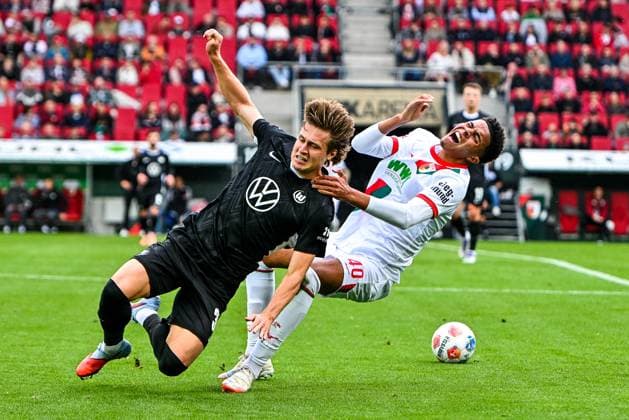 GER, 1 FBL, FC Augsburg vs VfL Wolfsburg 04 10 2025, WWK Arena, Augsburg, GER, 1 FBL, FC Augsburg vs VfL Wolfsburg, in the picture Mattias Svanberg VfL Wolfsburg, 32 hits Noahkai Banks FC Augsburg, 40 with his shoulder in the face, foul nordphotoxGmbHx xHafner nph00200