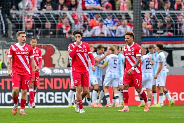 Cottbus players looking disappointed after conceding the 3-0 goal, disappointment, frustration, disappointed, pessimistic, in the background the players of TSV 1860 Muenchen cheer the goal, 01 11 2025, Munich Germany , Football, 3 Liga, TSV 1860 München FC Energie Cottbus, DFB DFL REGULATIONS PROHIBIT ANY USE OF PHOTOGRAPHS AS IMAGE SEQUENCES AND OR QUASI VIDEO xslx