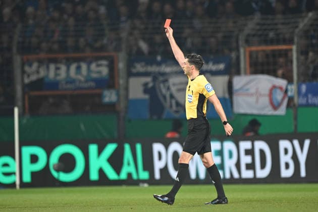 Referee Florian BADSTUEBNER, shows after video evidence, Koelner Keller, VAR, Video Assistant Referee, video referee, the red card, sending off, to Phiilipp STROMPF BO Football, DFB Cup, Round of 16, VfL Bochum BO VfB Stuttgart S on 03 12 2025, Vonovia Ruhrstadion Bochum Germany DFL regulations prohibit any use of photographs as image sequences and or quasi video Â