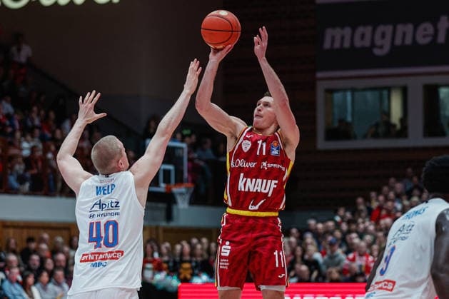 In the picture from left Collin Welp Syntainics MBC, 40 against Brae Ivey Wuerzburg Baskets, 11 21 12 2025, Basketball, Fitness First Wuerzburg Baskets vs SYNTAINICS MBC, easyCredit BBL, 11 Matchday, Germany, Wuerzburg, tectake Arena, Copyright: HMBxMedia xJulienxBecker
