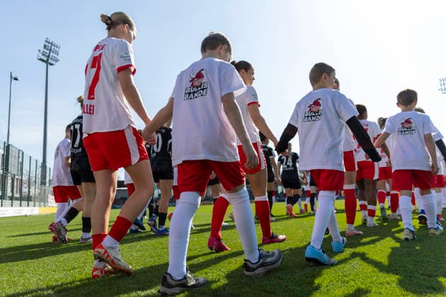 GER, Leipzig, Soccer, Google Pixel Women Bundesliga, 21 Matchday, RB Leipzig vs SC Freiburg in the picture from l Marlene Mueller RB Leipzig 27 , with the child at the hand runs onto the field with the teams, children wear Bullis Bande T Shirts, Childrens Club RB Leipzig 22 03 2025, RB Leipzig Training Academy Cottaweg Leipzig DFB REGULATIONS PROHIBIT ANY USE OF PHOTOGRAPHS AS IMAGE SEQUENCES AND OR QUASI VIDEO, Copyright: HMBxMedia PaulxFritz