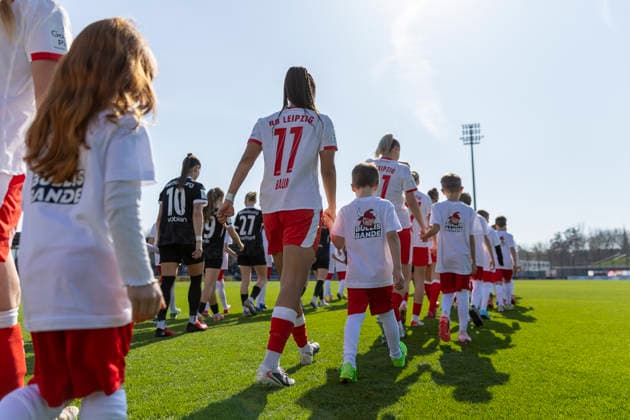 GER, Leipzig, Fußball, Google Pixel Frauen Bundesliga, 21 Spieltag, RB Leipzig vs SC Freiburg im Bild v l Lisa Baum RB Leipzig 11 , laueft mit den Mannschaften auf dem Feld, mit Einlaufkind an der Hand, EInlaufkind trägte Bullis Bande T Shirt RB Leipzig Kinderclub 22 03 2025, RB Leipzig Training Akademie Cottaweg Leipzig DFB REGULATIONS PROHIBIT ANY USE OF PHOTOGRAPHS AS IMAGE SEQUENCES AND OR QUASI VIDEO, Copyright: HMBxMedia PaulxFritz