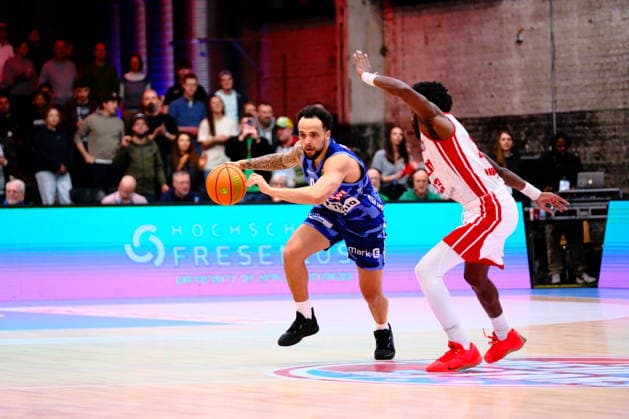 ProA RheinStars Cologne vs Phoenix Hagen, Cologne, 23 03 2026, Motorworld Cologne Marcus Henri Graves 0, Phoenix Hagen, PG on offense, defended by Adam John Paige 13, RheinStars Cologne, PF ProA RheinStars Cologne vs Phoenix Hagen, Cologne, 23 03 2026, Motorworld Cologne Copyright: xBEAUTIFULxSPORTS Piepenstockx