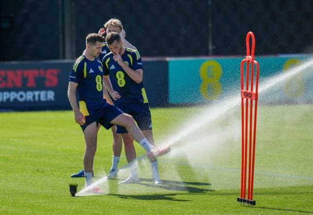 Kenny McLean of Scotland cools his feet under a sprinkler during a training session on a hot afternoon at Lesser Hampden. Scotland Team Training, Football, Hampden Park, Glasgow, Scotland, UK - 26 May 2026Glasgow Hampden Park United Kingdom EDITORIAL USE ONLY No use with unauthorised audio, video, data, fixture lists, club league logos or live services. Online in-match use limited to 120 images, no video emulation. No use in betting, games or single club league player publications. Copyright: xStuartxWallace Shutterstockx 16898315h
