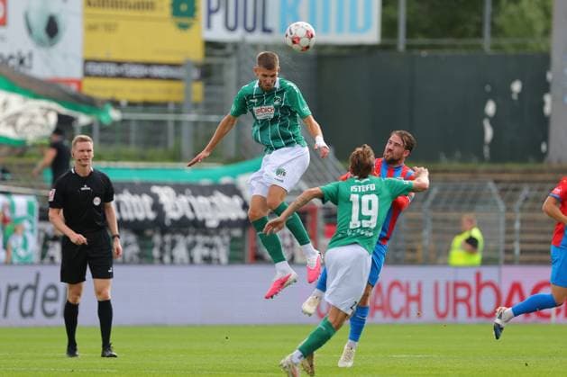 August 26, 2029, Germany, Regionalliga Nord, Soccer, Matchday 6, 2026–2027 Season, VfB Lübeck vs. SV Drochtersen Assel: A header duel between Selim Ajkic (VfB Lübeck 09) and Nico von der Reith (SV Drochtersen Assel 12); Fabian Istefo (VfB Lübeck 19) in the foreground on the left; referee Mika Jungclaus Lübeck, Dietmar Scholze Stadium at the Lohmühle, SH, Germany Copyright: xnordphotoxGmbHx xTauchnitzx