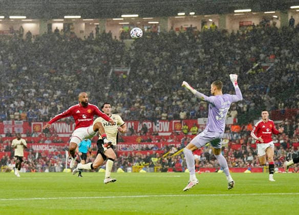 Manchester, England, 30th August 2026. Bryan Mbeumo of Manchester United, ManU lifts the ball over Kjell Scherpen of Ipswich Town to score the fifth goal during the Manchester United vs Ipswich Town Premier League match at Old Trafford, Manchester. Picture credit should read: Andrew Yates Sportimage EDITORIAL USE ONLY. No use with unauthorised audio, video, data, fixture lists, club league logos or live services. Online in-match use limited to 120 images, no video emulation. No use in betting, games or single club league player publications. SPI_085_AY_Man_Utd_Ipswich SPI-4945-0086