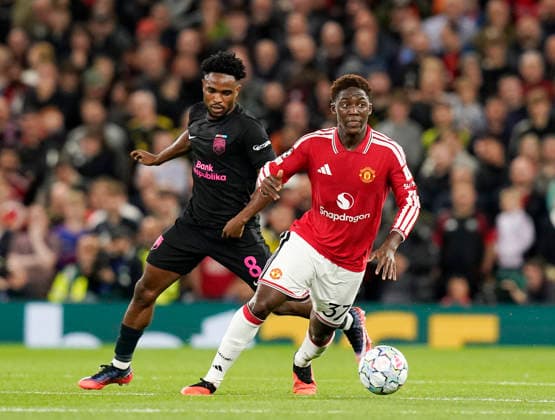 Manchester, England, 10th September 2026. Christian Nwachukwu of Sabah FC tussles with Kobbie Mainoo of Manchester United, ManU during the Manchester United vs Sabah UEFA Champions League match at Old Trafford, Manchester. Picture credit should read: Andrew Yates Sportimage EDITORIAL USE ONLY. No use with unauthorised audio, video, data, fixture lists, club league logos or live services. Online in-match use limited to 120 images, no video emulation. No use in betting, games or single club league player publications. SPI_028_AY_Man_Utd_Sabah SPI-4989-0028