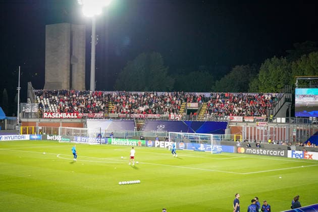 Italy Soccer UEFA Champions League 2026–2027, Matchday 1: Como 1907 vs. RB Leipzig at the Giuseppe Sinigaglia Stadium in Como under floodlights; wide shot; interior view of the visitors section with RB Leipzig fans; flags, banners, and signs, including RASENBALL players warming up on the field; soccer, Champions League, spectators, fan culture, away fans, goal, floodlights, advertising boards, Mastercard, FedEx, Heineken, Pepsi, PS5 Copyright: xJOERANxSTEINSIEKx