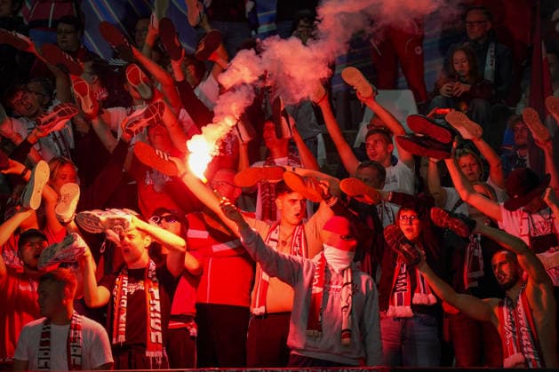 Italy Soccer UEFA Champions League 2026–2027, Matchday 1: Como 1907 vs. RB Leipzig at Giuseppe Sinigaglia Stadium. Como: RB Leipzig fans in the visitors’ section hold their shoes aloft during a choreographed display, while a fan lights a Bengalo pyrotechnic. Soccer, Champions League, RB Leipzig, away fans, spectators, fans, ultras, fan culture, fan choreography, choreography, pyrotechnics, Bengalo, smoke, visitors’ section, fan block, atmosphere, emotions Copyright: xJOERANxSTEINSIEKx