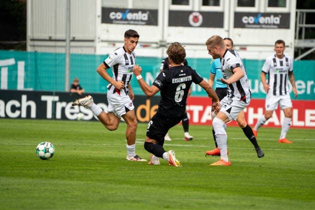 German Soccer, 3rd Division, 2026–27, Matchday 7, September 19, 2026 FC Viktoria Köln vs. FC Ingolstadt 04 Sportpark Höhenberg, Cologne Tobias Eisenhuth, FC Viktoria Köln, No. 6 chips the ball past Lars Lokotsch (FC Ingolstadt 04), No. 13 clears it, and Georgios Antzoulas (FC Ingolstadt 04), No. 6, watches—Cologne, Germany Copyright: xMijoxLubecx