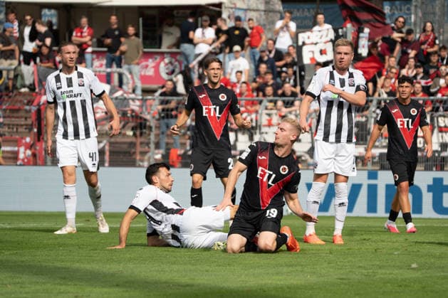 German Soccer, 3rd Division, 2026–27, Matchday 7, September 19, 2026, FC Viktoria Köln vs. FC Ingolstadt 04, Sportpark Höhenberg, Cologne. Meiko Sponsel (FC Viktoria Köln, 19) blocks the ball from Lukas Fröde (FC Ingolstadt 04, 34) while Vinko äapina (FC Ingolstadt 04, 41, Lucas Wolf (FC Viktoria Cologne, 21), and Lars Lokotsch (FC Ingolstadt 04, 13) look on. Cologne, Germany Copyright: xMijoxLubecx