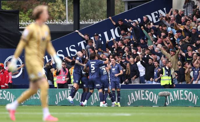 Millwall fans celebrate the first Millwall goal at the Millwall v West Ham EFL Championship match at The New Den. Millwall v West Ham United, EFL Sky Bet Championship, Football, The Den, London, UK - 19 Sep 2026London The Den United Kingdom EDITORIAL USE ONLY No use with unauthorised audio, video, data, fixture lists, club league logos or live services. Online in-match use limited to 120 images, no video emulation. No use in betting, games or single club league player publications. Paul M Copyright: xPaulxMarriott Shutterstockx 17158320bf