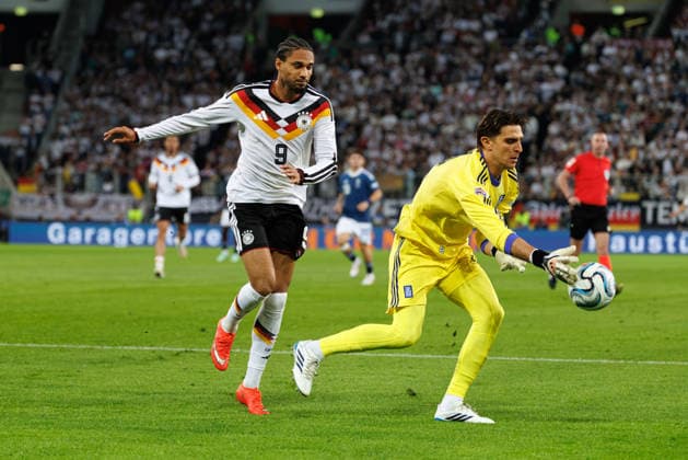 Kostas Tzolakis 12, Greece, ahead of Kevin Schade 9, Germany, in the match between Germany and Greece, men s soccer, UEFA Nations League, 2026–2027, Matchday 2 on September 27, 2026, in Augsburg, WWK Arena, Bavaria, Germany