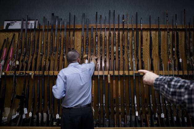 Feb. 19, 2013 - Redding, CA, USA - Redding Vice mayor and the owner of a gun shop Patrick Jones picks up a shotgun to show it to a customer, John Robinson, right, of Redding in his store on February 19, 2013. Shasta County has the highest per-capita rate of gun background checks, indicating attempts to buy firearms, of any county in California, which has some of the nation s strictest gun laws. - ZUMAgun