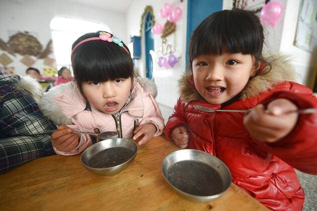 January 4, 2017 - Lianyungang, Lianyungang, China - Lianyungang, CHINA-January 4 2017: (EDITORIAL USE ONLY. CHINA OUT)..Pupils enjoy the Laba rice porridge at a primary school in Donghai County, Lianyungang City,east China s Jiangsu Province, January 4th, 2017, celebrating the Laba Rice Porridge Festival which falls on January 5th this year. The Laba Rice Porridge Festival is a traditional Chinese festival falls on the 8th day of the 12th month of lunar calendar. It s customary on this day to drink the special porridge, usually stewed of at least eight ingredients. With rice as the main ingredient, this porridge may well contain ingredients like broad beans, red beans, mung beans, red dates, peanuts, chest nuts, both tasty and nutritious. Lianyungang China - ZUMAs145 20170104_zaa_s145_192