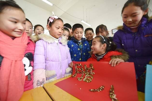 January 4, 2017 - Lianyungang, Lianyungang, China - Lianyungang, CHINA-January 4 2017: (EDITORIAL USE ONLY. CHINA OUT)..Pupils learn to recognize five kinds of cereals under the guidance of teacher at a primary school in Donghai County, Lianyungang City,east China s Jiangsu Province, January 4th, 2017, celebrating the Laba Rice Porridge Festival which falls on January 5th this year. The Laba Rice Porridge Festival is a traditional Chinese festival falls on the 8th day of the 12th month of lunar calendar. It s customary on this day to drink the special porridge, usually stewed of at least eight ingredients. With rice as the main ingredient, this porridge may well contain ingredients like broad beans, red beans, mung beans, red dates, peanuts, chest nuts, both tasty and nutritious. Lianyungang China - ZUMAs145 20170104_zaa_s145_202