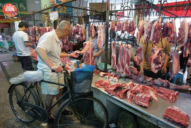 May 28, 2007 - Wuhan, Hubei, CHINA - Local residents choose pork at a market in Chengdu of China s Sichuan province on Monday, May 28 2007. China s premier has called for steps to stabilise pork supplies and rein in soaring prices of the staple meat, warning social stability is at stake without a solution, state media reported Monday. According to the Ministry of Agriculture, in April live pigs nationwide were priced 71.3 percent higher than a month earlier, and pork, 29.3 percent higher, largely due to tightened supply. - ZUMA 20070528_kri_c32_001