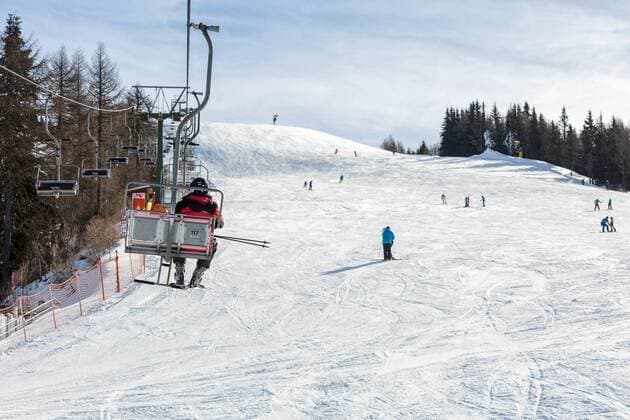 20.12.2017, San Candido, Italien - Sessellift über einer Skipiste in einem Skigebiet in den Dolomiten. . (Winter, Winterwetter, winterlich, Schnee, Skipiste, Tourismus, Wintertourismus, Wintersport, Sport, Hobby, Sonne, Sonnig, Berge, Dolomiten, Südtiroler Pustertal, Südtirol, Suedtirol, Pustertal, Innichen, San Candido, Schipiste, Skigebiet, verschneit, Ski, Skifahrer, Schi, Skisport, Schisport, Skier, Schier, Skifahren, Abfahrt, Schifahren, Skilaufen, Schilauf, Piste, Skiern, Breitensport, Lift, Skilift, Sessellift, Sesselbahnen, Umlaufseilbahn, Seilbahn, Verletzungegefahr, Verletztungsgefahren, gefahren, Unfallgefahren, Helm Tragen, ohne Helm, ohne Schutzhelm, ohne Skihelm, mit Helm, mit Schutzhelm, mit Skihelm, Skihelm, Helm, Snowboarder, Snowboard, Snowboardfahrer, Snowboardfahren, Snowboarden, Europa, Mitteleuropa, aussen, Auss