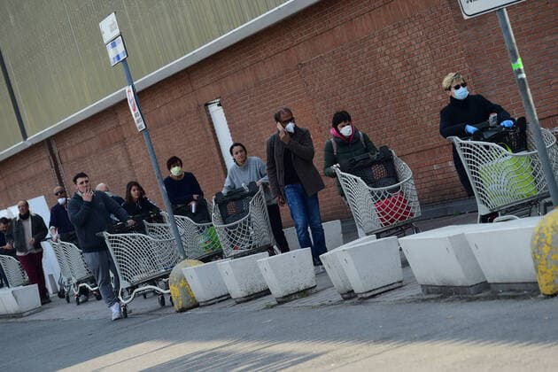 (200321) -- ROME, March 21, 2020 (Xinhua) -- People wait outside a supermarket in Bologna, Italy, March 20, 2020. Italy s Ministry of Health on Friday took the unprecedented step of closing all public parks, gardens and other open spaces, effective from Saturday. The coronavirus pandemic has claimed 4,032 lives in locked down Italy by Friday, with the number of cumulative cases reaching 47,021, according to new data released by the Civil Protection Department. (Photo by Gianni Schicchi Xinhua) ITALY-COVID-19-LOCKDOWN