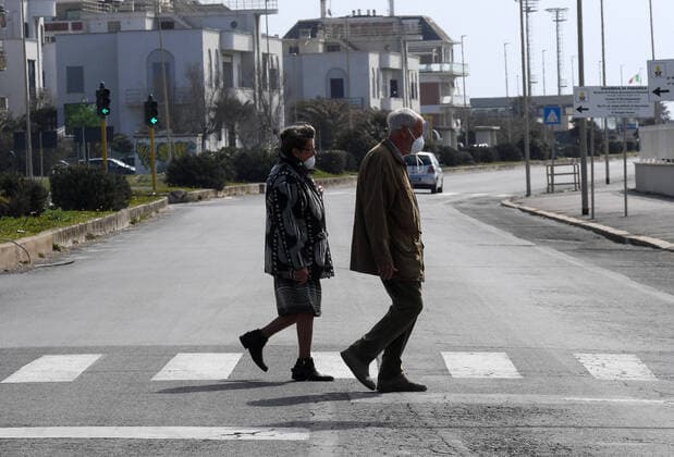 (200321) -- ROME, March 21, 2020 (Xinhua) -- People wearing face masks cross a street in Ostia, Rome, Italy, March 21, 2020. Italy reported 6,557 new cases of coronavirus on Saturday, raising the total to 53,578 since the pandemic first broke out in its north on Feb. 21, according to the latest data provided by the Civil Protection Department managing the COVID-19 emergency. (Photo by Elisa Lingria Xinhua) ITALY-ROME-OSTIA-COVID-19-CASES