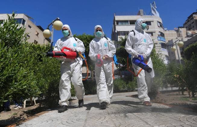 March 22, 2020, Gaza City, Gaza Strip, Palestinian Territory: Palestinian workers disinfect the streets, as a preventive measure amid fears of the spread of the coronavirus, in Gaza City on March 22, 2020. Authorities in Gaza confirmed the first two cases of novel coronavirus, identifying the individuals as Palestinians who had travelled to Pakistan and were held in quarantine on their return. The United Nations has warned that a COVID-19 outbreak in Gaza could be disastrous, given the high poverty rates and weak health system in the coastal strip under Israeli blockade since 2007. Authorities in Gaza have said that more than 2,700 Palestinians are in home-isolation, mostly people who had returned from Egypt Gaza City Palestinian Territory - ZUMAap3_ 20200322_zaf_ap3_130 Copyright: xAshrafxAmrax