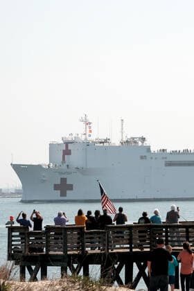 March 28, 2020, Norfolk, Virginia, United States Of America: NORFOLK, VA - MARCH 28: People gather to watch the Military Sealift Command hospital ship USNS Comfort (T-AH 20) depart Naval Station Norfolk, Va., March 28, 2020. Comfort is deploying in support of the nations COVID-19 response efforts and will serve as a referral hospital for non-COVID-19 patients currently admitted to shore-based hospitals. This allows shore-based hospitals to focus their efforts on COVID-19 cases. One of the Department of Defenses missions is Defense Support of Civil Authorities. DoD is supporting the Federal Emergency Management Agency, the lead federal agency, as well as state, local and public health authorities in helping protect the health and safety of the American people. on March 28, 2020 in Norfolk, Virginia..People: USNS Comfort Norfolk Unit - ZUMAn287 20200328_zaa_n287_007 Copyright: xSMGx