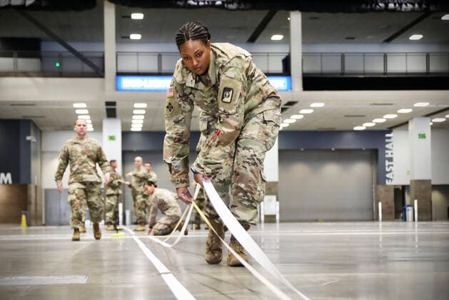 March 29, 2020 - Seattle, Washington, USA - Army Staff Sgt. Ladenna Ruiz, a pharmacy technician and native of Pomona, California, assigned to Company B, 47th Combat Support Hospital, helps lay down white tape on the floor of the Centurylink Field Event Center in downtown Seattle, Washington March 29, to mark the location of incoming medical equipment and supplies. The center is being transformed into a top-notch Army temporary medical facility in the days ahead to provide care to non-COVID-19 infected patients from local hospitals and allow local medical professionals to focus on treating COVID-19. U.S. Northern Command is providing military support to the Department of the Health and Human Services as well as FEMA in order to help combat the spread of COVID-19. Seattle USA - ZUMAz03_ 20200329_sha_z03_386 Copyright: xU.S.xArmyx