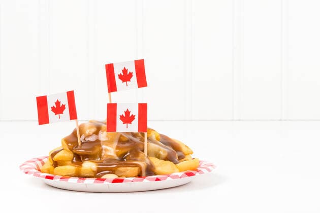 Canadian Poutine A plate of poutine, a unique dish that originated from the province of Quebec.food, fast, poutine, french fries, potato, cheese, curd, gravy, plate, Canadian, flag, cuisine, Quebec, red, white, maple leaf, unique, traditional, delicious, tasty, brown, comfort, copy space,