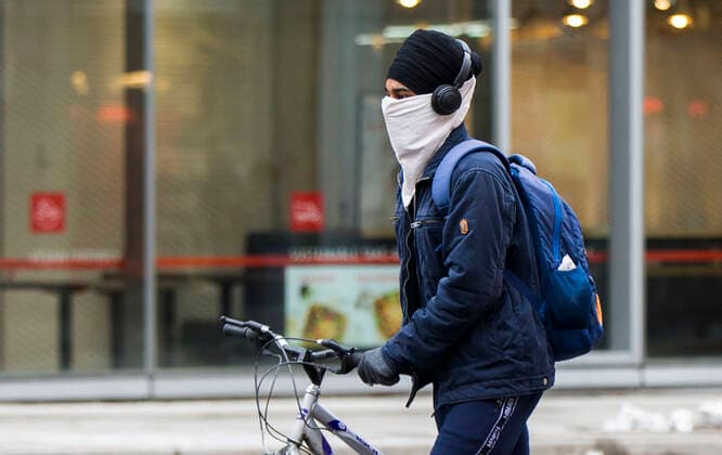 (201228) -- TORONTO, Dec. 28, 2020 -- A man wearing a face covering walks a bicycle on the street in Toronto, Ontario, Canada, Dec. 27, 2020. Canada s COVID-19 cases surpassed 550,000, with the total hitting 552,020, including 14,963 deaths, as of Sunday afternoon, according to CTV. Ontario, the most populous province in Canada, reported 2,005 new cases, bringing its total case count to 171,416 on Sunday. (Photo by Xinhua) CANADA-ONTARIO-COVID-19 ZouxZheng