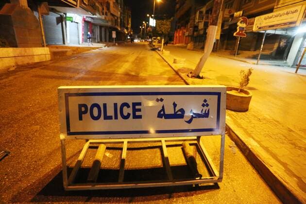 March 27, 2021, Deir Al-Balah, Gaza Strip, Palestinian Territory: Palestinian policemen wear face masks, guard a barrier blocking a road, in Deir Al-Balah in the center of the Gaza Strip, on March 27, 2021, after the Ministry of Interior in Gaza City announced the full lockdown on Saturday all over the Gaza Strip at night-time from 9:00 PM, after the increase in cases infected with Coronavirus Deir Al-Balah Palestinian Territory - ZUMAap3_ 20210327_zaf_ap3_215 Copyright: xAshrafxAmrax