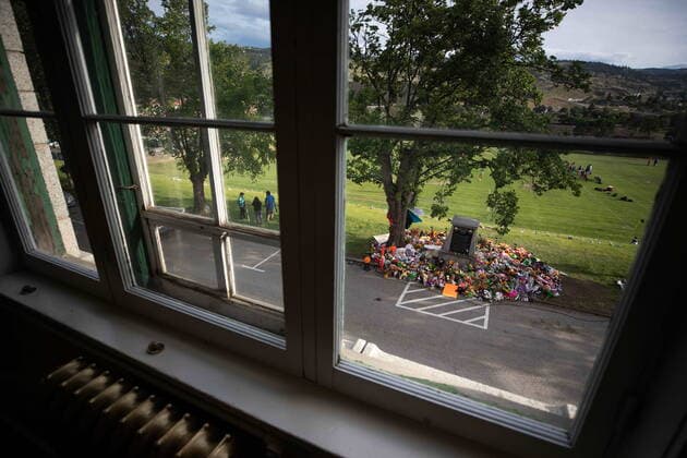 June 4, 2021, Kamloops, BC, Canada: Seen through an upper window of the former Kamloops Indian Residential School, a makeshift memorial to honour the 215 children whose remains have been discovered buried near the facility surrounds a monument, in Kamloops, B.C., on Friday, June 4, 2021. Kamloops Canada - ZUMAc35_ 20210604_zaf_c35_146 Copyright: xDarrylxDyckx